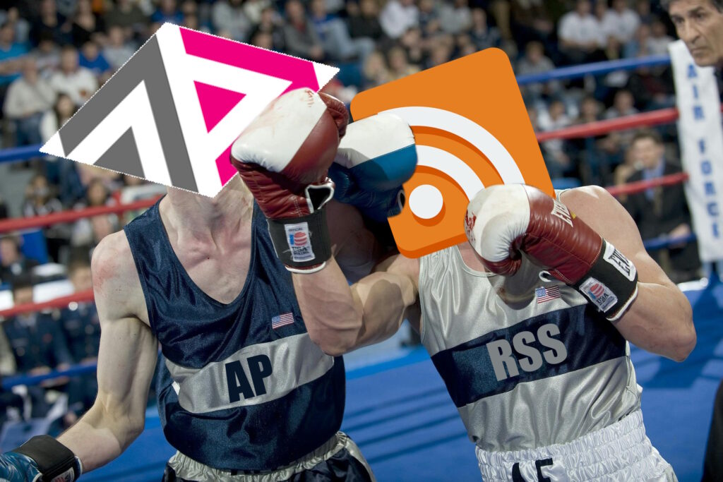 Photograph of a boxing match, but with the heads of the competitors replaced with the ActivityPub and RSS logos (and "AP" or "RSS" written on their clothes, respectively). RSS is delivering a powerful uppercut to ActivityPub.