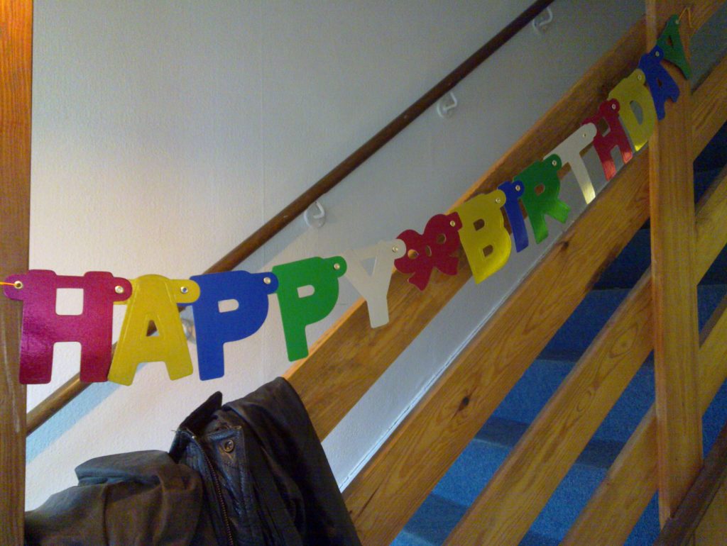 A 'Happy Birthday' banner in the hallway of Earth.