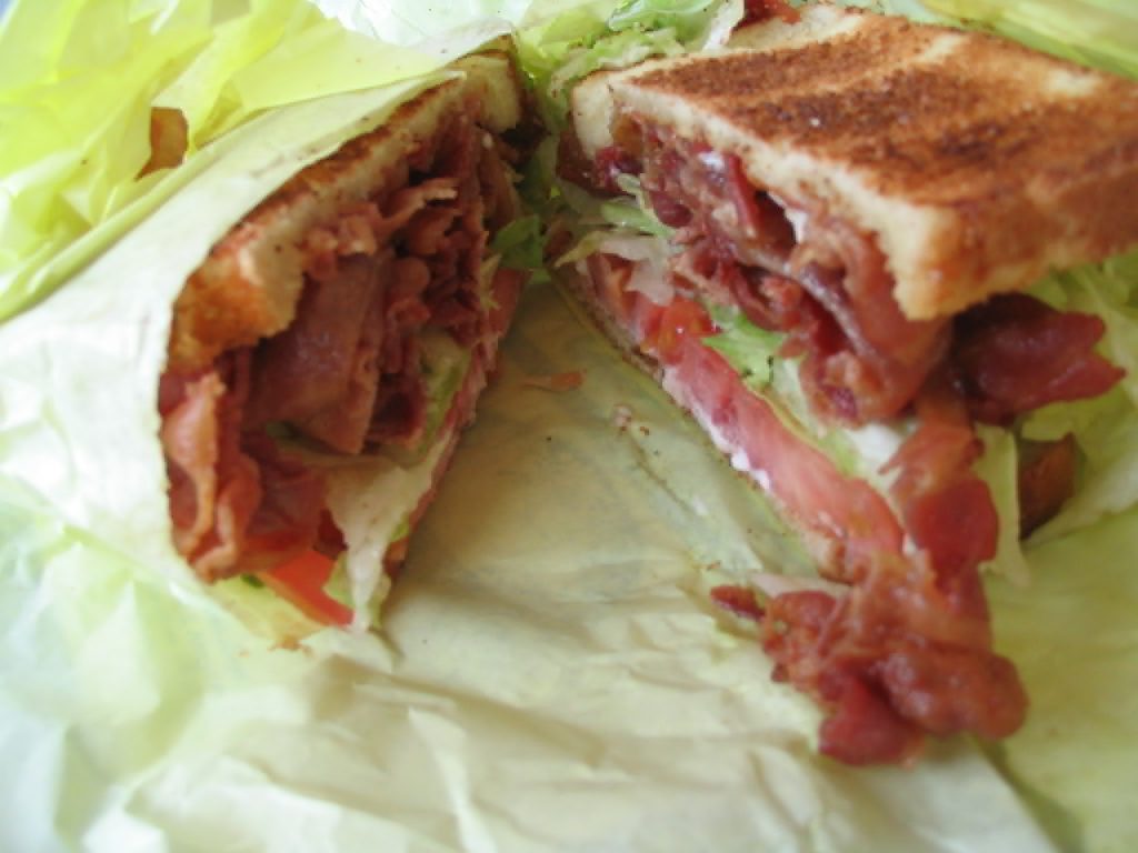 A toasted sandwich containing bacon, lettuce, and tomato.