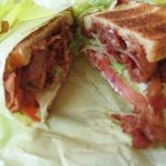 Close-up cross-section of a BLT sandwich on toasted bread.