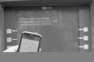 Entering a 6-digit code from a mobile phone into a cash machine.