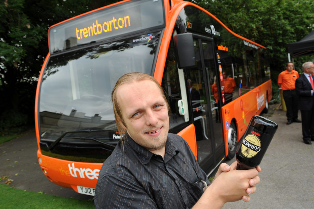 I hold a bottle of Guinness in preparation of "breaking" it over the front of the bus.