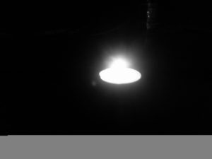 A tealight candle burning in the dark.