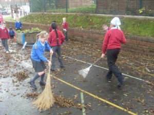 Children sweeping at Holme Slack playground.