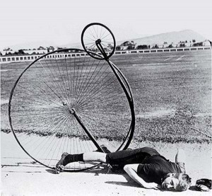 A penny farthing: the rider has tipped over the handlebars and ended up thoroughly upside-down.