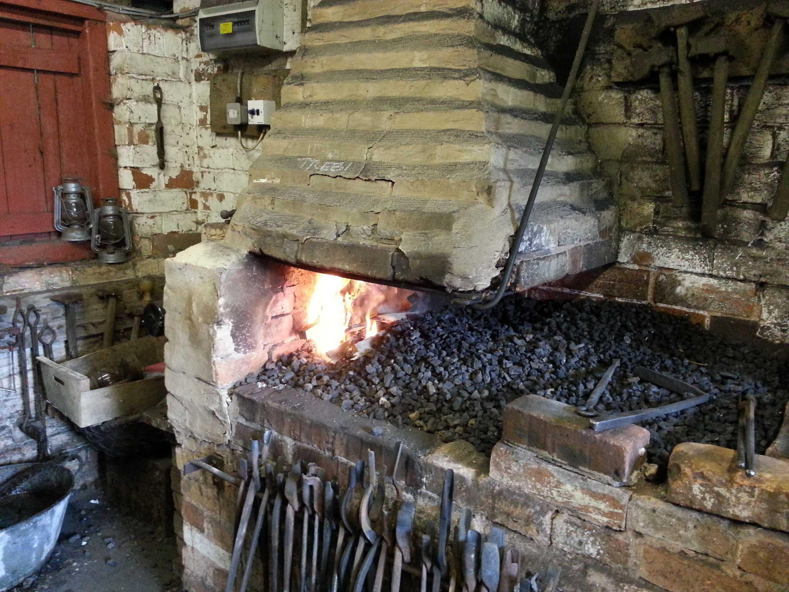 A blacksmith's hearth: the fire is just lit.