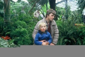 Dan sits on his father's knee. 1980s.