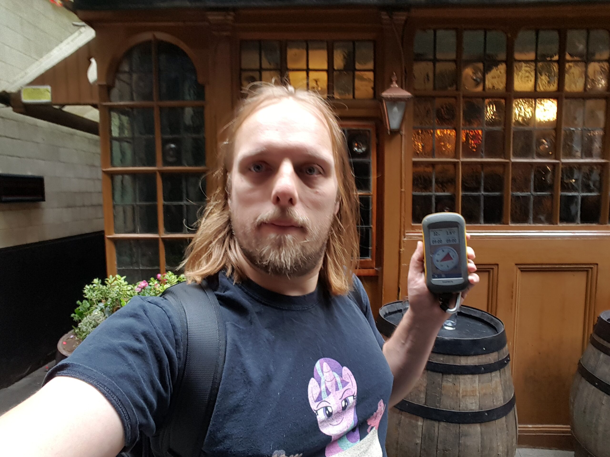 Dan, outside a pub, holding a GPS receiver.