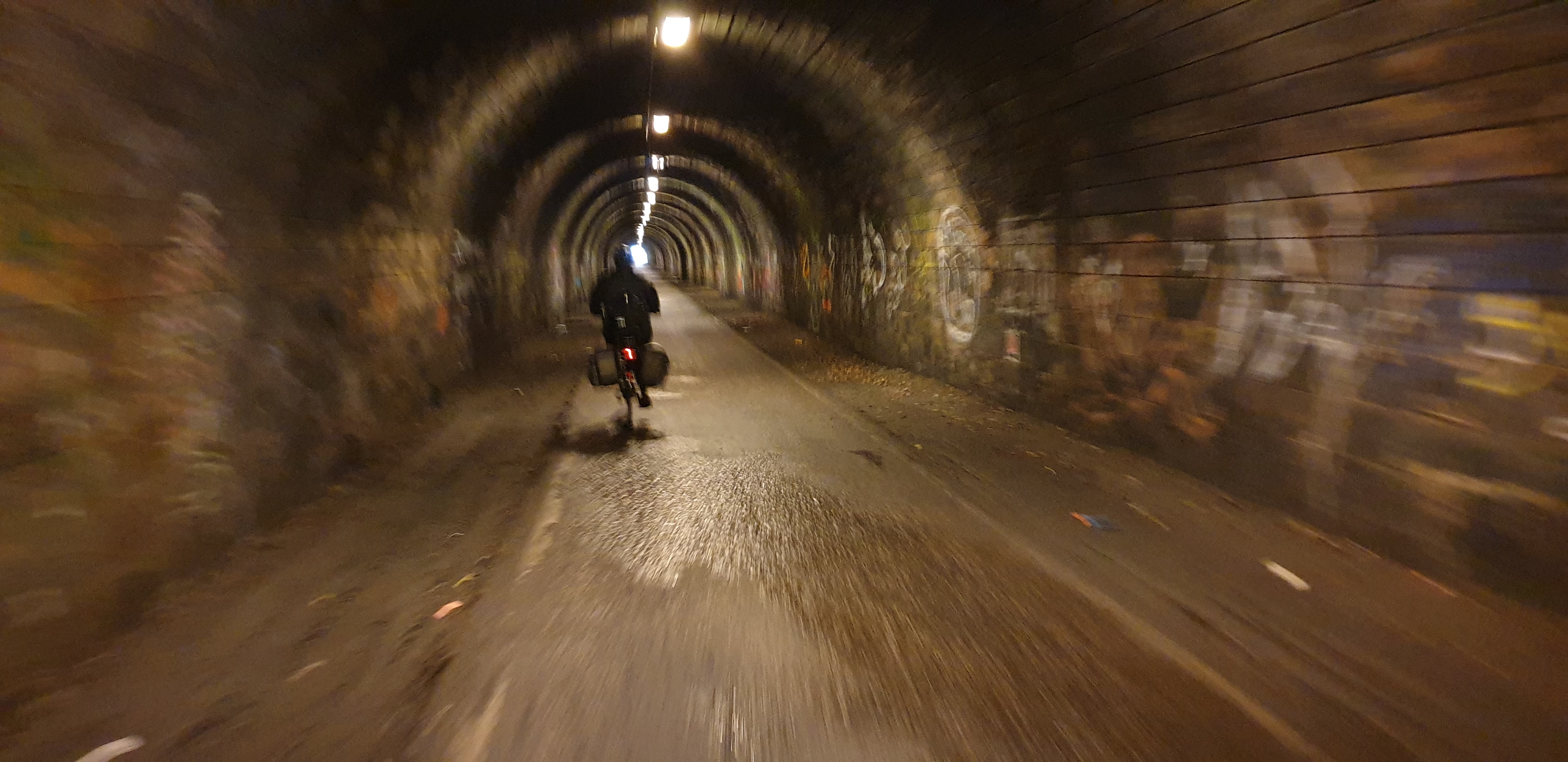 Ruth cycles through the former railway tunnel of The Innocent Railway.