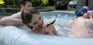 Annabel eats watermelon in the hot tub.