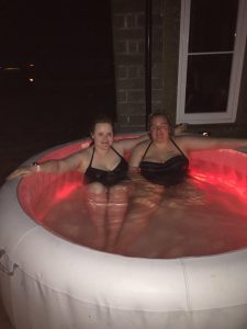 Jemma and Becky in the hot tub, in the dark.