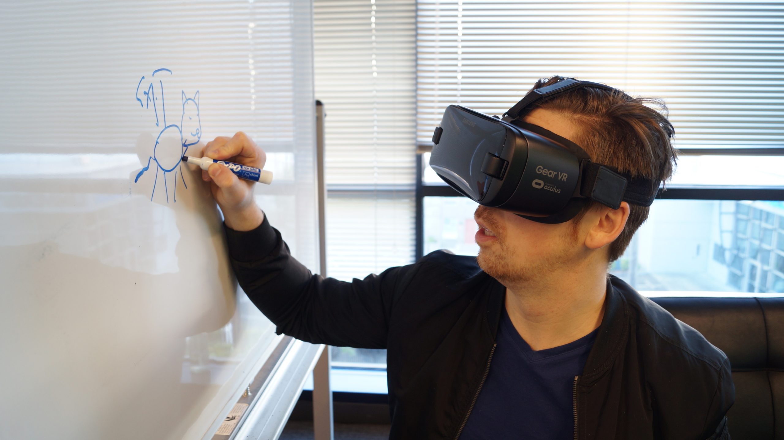 A man wearing a VR headset while writing on a whiteboard.