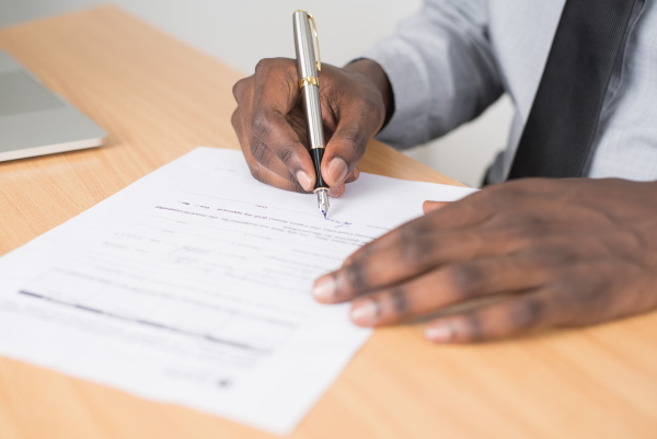 A man signs a document.