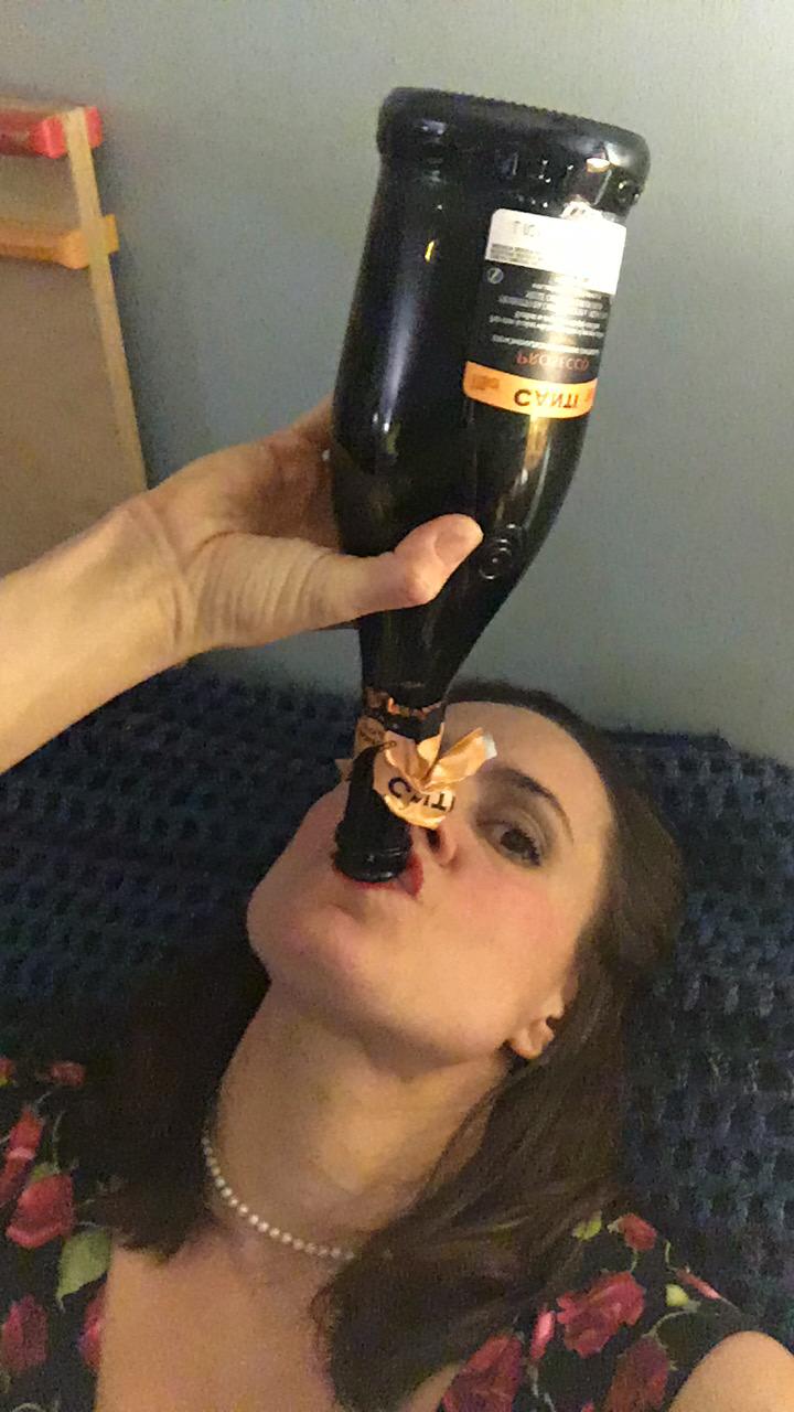 Jen drinking from the neck of a nearly-empty wine bottle.