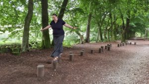 Ruth hops across balancing logs in the Darwin Forest.