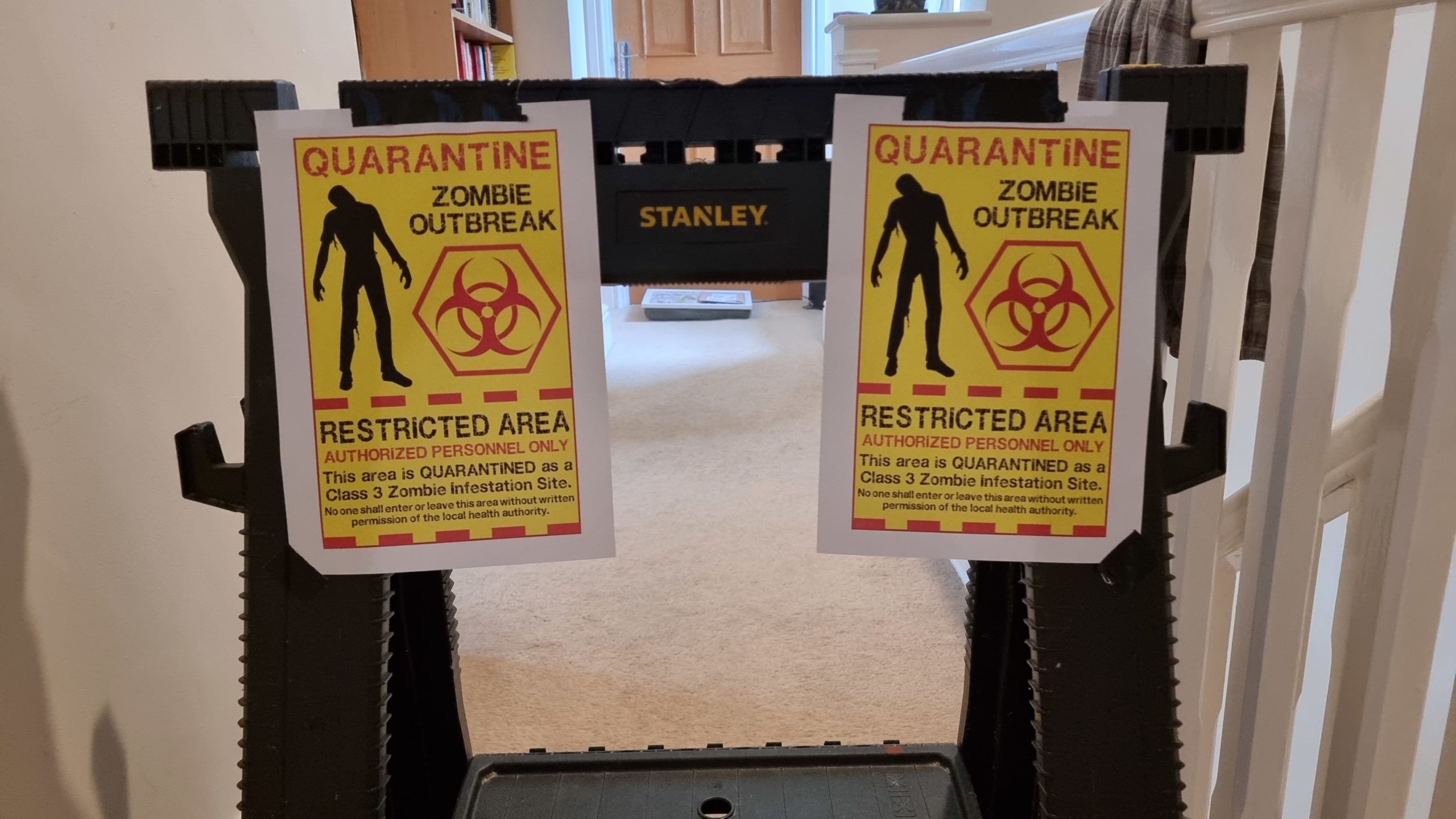 Barricade with signs reading "Quarantine: Zombie Outbreak"