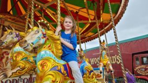 A girl on a carousel horse called "Annie".
