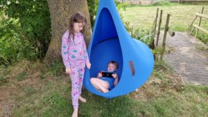 The kids play switch while they hang in a 'nest swing'.