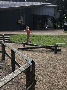 Boy balancing on a beam at a park.