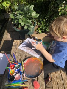 A boy doing finger painting.