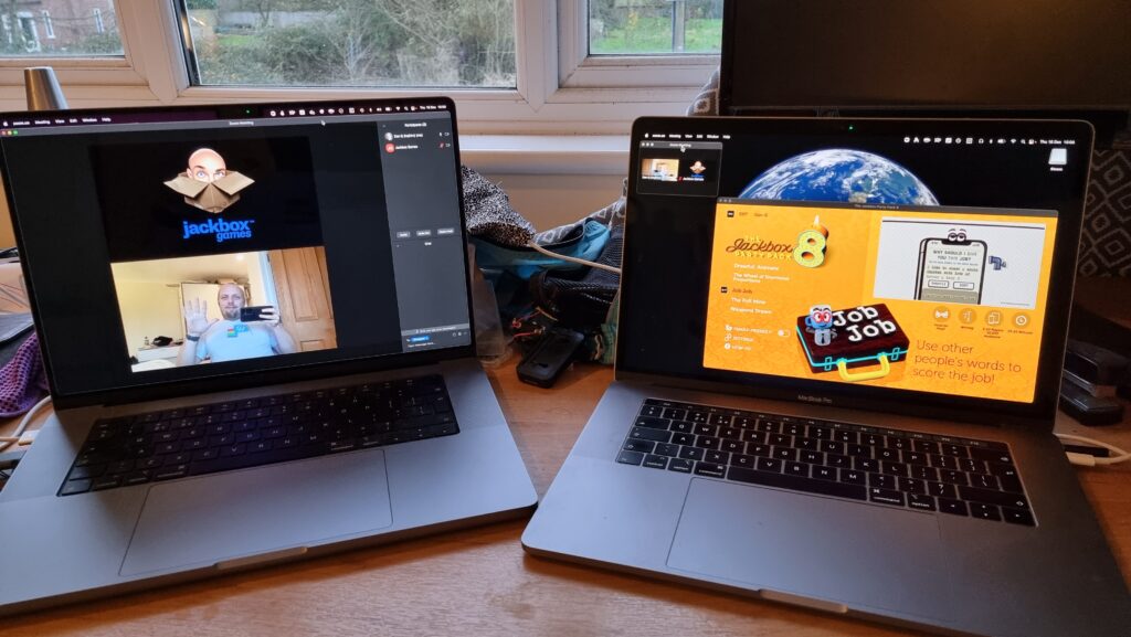 Two laptops: one showing a full-screen Zoom chat with Dan and "Jackbox Games"; the second showing a windowed copy of Jackbox Party Pack 8.