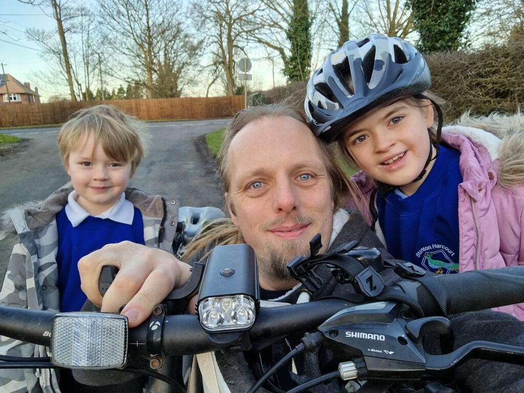 Dan with the kids and his bike, on the way to school.