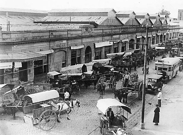 The "Mercado de Abasto" (central wholesale fruit and vegetable market) of Rosario, Argentina, 1931. Horses with carts work alongide automobiles and an omnibus.