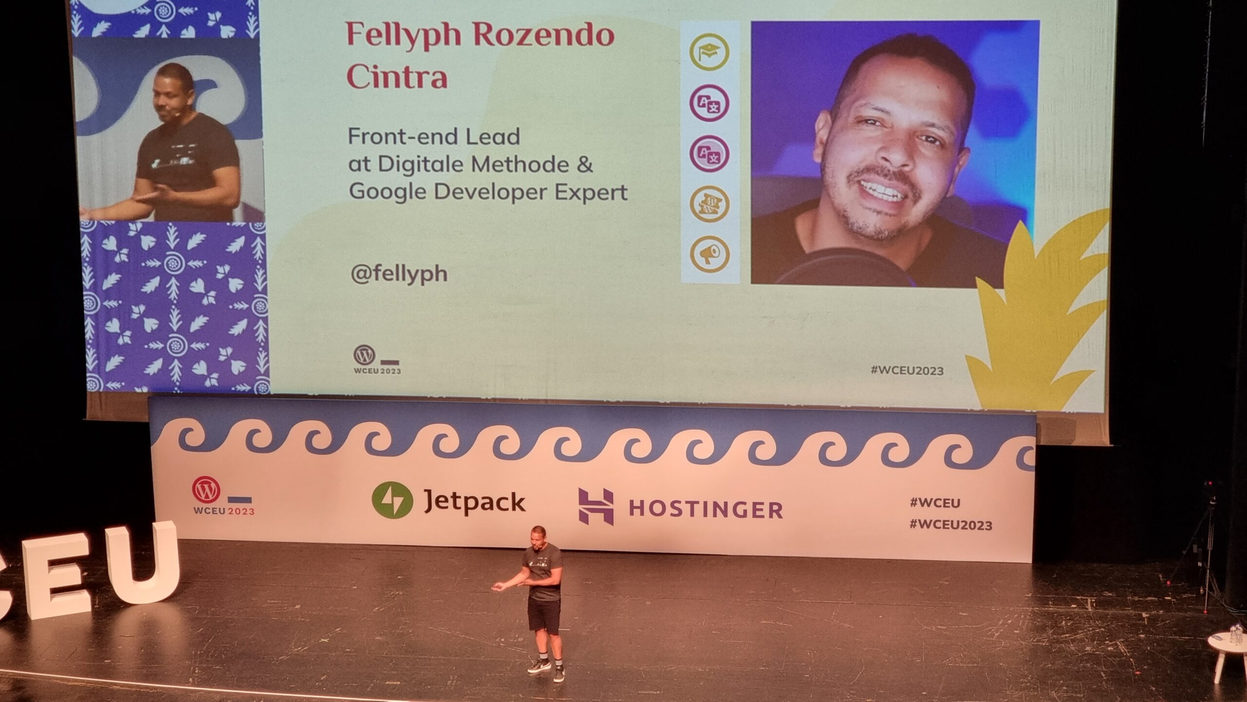 Fellyph Cintra stands in front of a large screen showing a slide that introduces himself to his audience: "Front-end Lead at Digitale Methode & Google Developer Expert @fellyph"