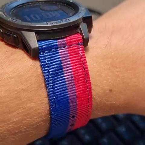 Photograph showing Dan's wristwatch, worn, side-on; its strap is in the style of the Bisexual Pride flag - three solid horizontal bars: two fifths pink, one fifth purple, and two fifths blue.