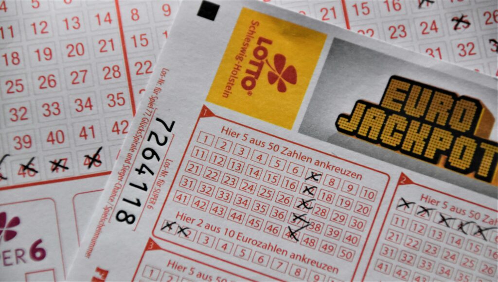 "LOTTO Schleswig-Holstein" player slip with two "series" of numbers selected: in game one, all the numbers ending 7, and the lucky stars 1 and 2; in the second game, the first five numbers (the lucky stars aren't visible).