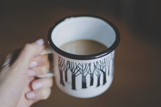 A mug of tea held by the handle.