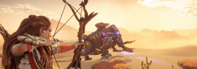 Aloy aims a precision longbow at a Tremortusk, an elephant-like machine, in a sunny desert environment.