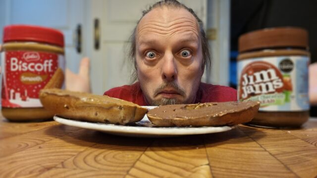 Dan, looking confused, next to a cinnamon and raisin bagel with JimJams on one half and Biscoff on the other half (and their respective jars).