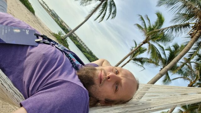 Dan lies in a hammock under a warm sun, smiling.