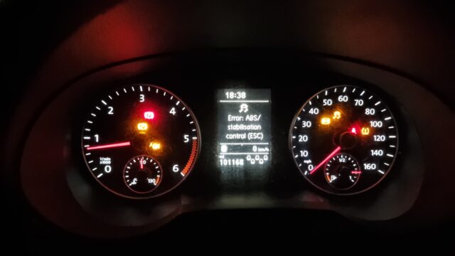 Car dashboard with seven different warning lights on, plus a message advising that ABS and ESC are not working.