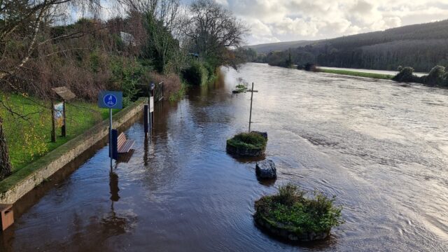 A riverside footpath is completely flooded.