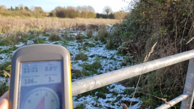 GPSr showing 106m, snowy overgrown field ahead.