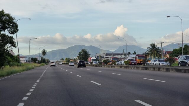 Six-lane highway as viewed through a windscreen. Traffic ahead is flowing well but there's a jam underway on the opposite carriageway.