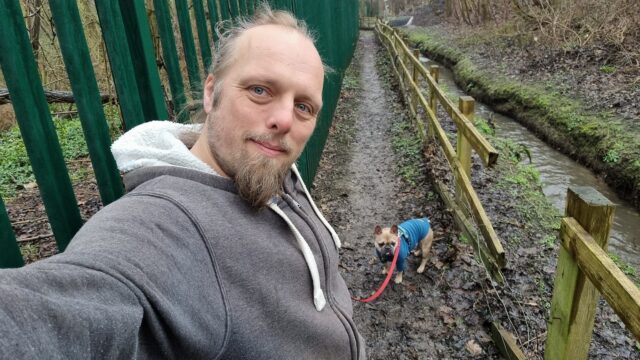 Dan with his dog on a muddy footpath.