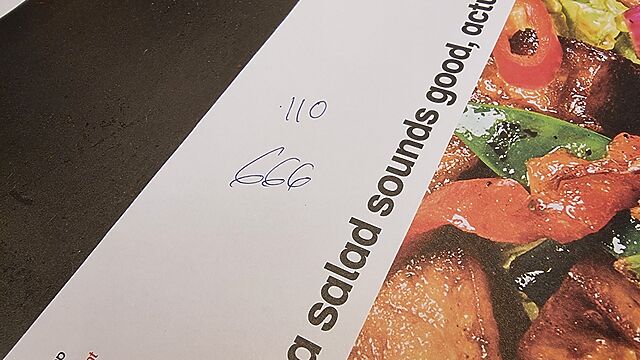 Wagamama restaturant placemat on which the waitstaff has written my order item numbers: 110, and 666.