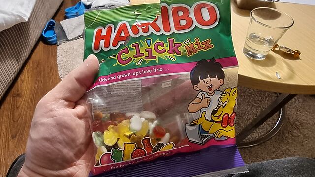 A bag of Haribo ClickMix, opened, held on a white hand.