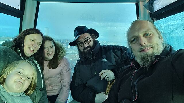 Dan, Ruth and JTA sit with their two children in the cabin of a ferris wheel.