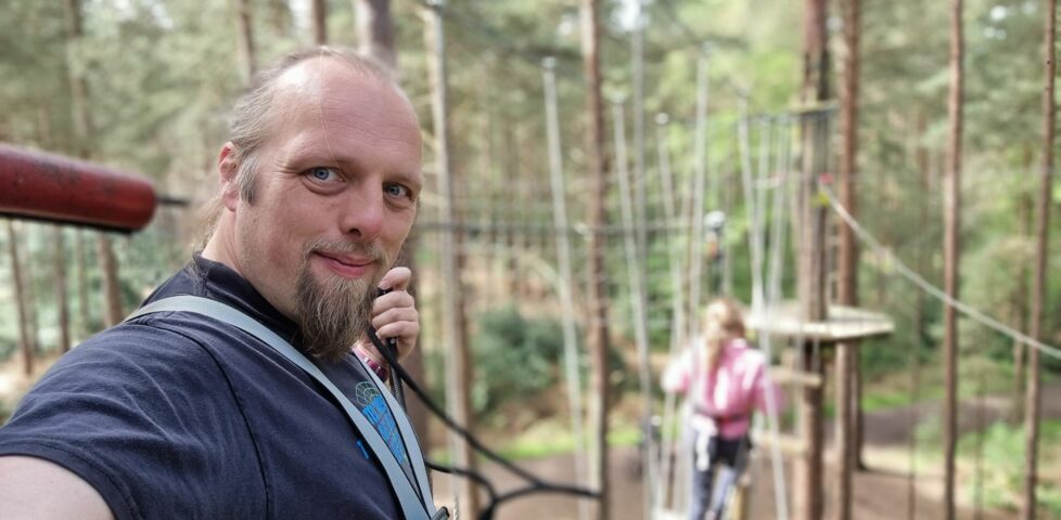 Dan takes a selfie from a high-ropes course, up a tree.