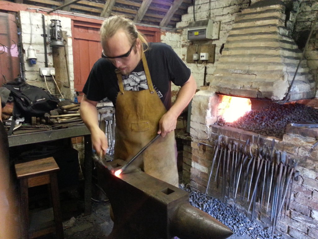 Dan hammers out a point on an anvil.