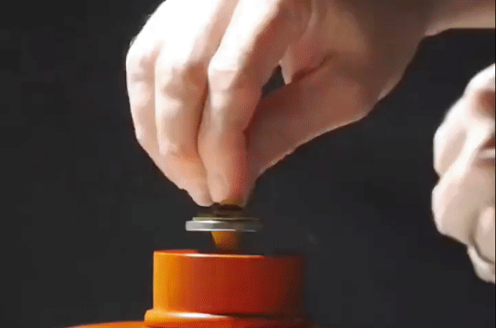Magnetically levitating spinning top amongst smoke; animated GIF