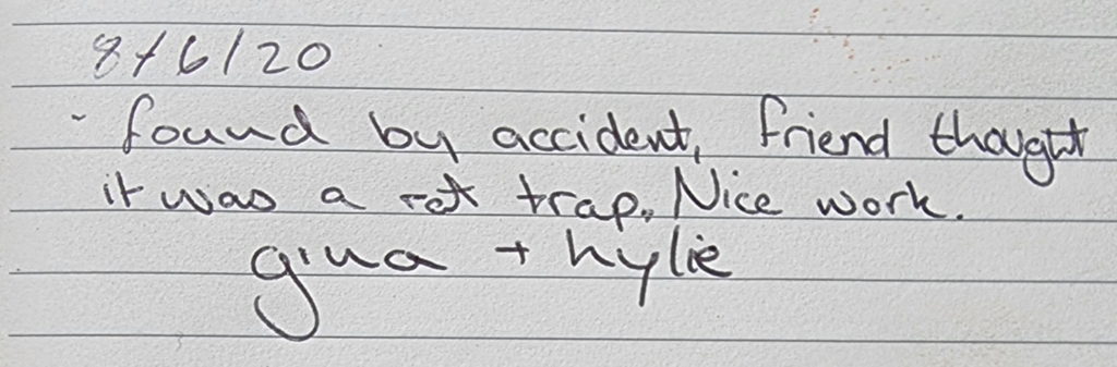 Handwritten note from the geocache log: "8/6/20 found by accident, friend thought it was a rat trap. Nice work. gina + kylie"
