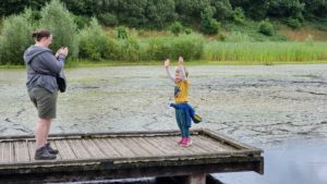 Ruth photographs her 4-year-old as he stands on a pontoon dock.