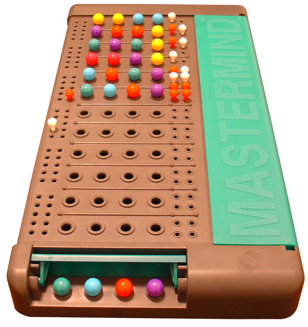A plastic Mastermind board in brown and green; it has twelve spots for guessing and shows six coloured pegs. The game has been won on the sixth guess.