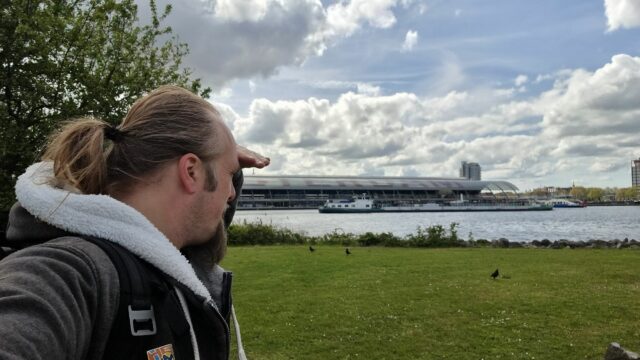 Dan puts his hand to his brow as he looks out to sea near Amsterdam.