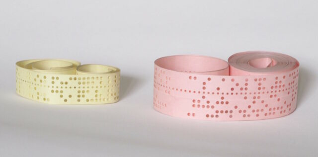 Two rolls of punched paper tape.